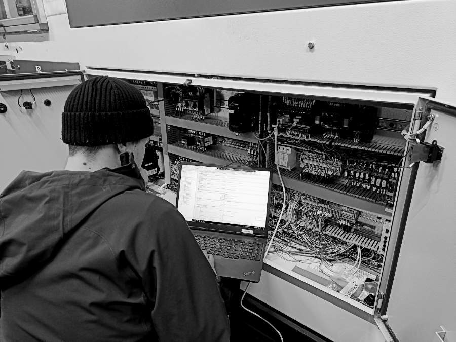 Automaatioinsinööri tutkimassa järjestelmän toimintaa ja mahdollisia vikoja kunnossapitoympäristössä.